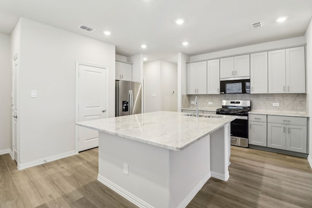 kitchen featuring visible vents, stainless steel appliances, light wood-type flooring, and a sink