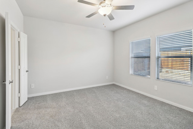 carpeted empty room with baseboards and ceiling fan