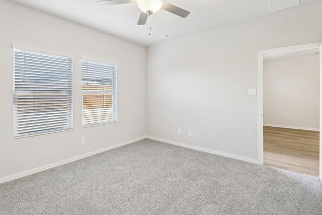 unfurnished room with visible vents, baseboards, a ceiling fan, and carpet floors