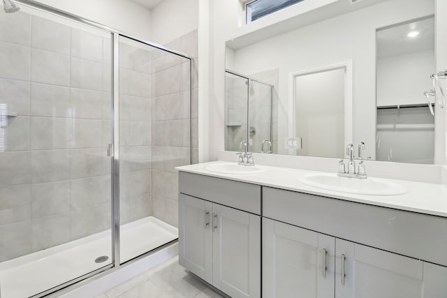 full bathroom with a sink, a stall shower, and double vanity