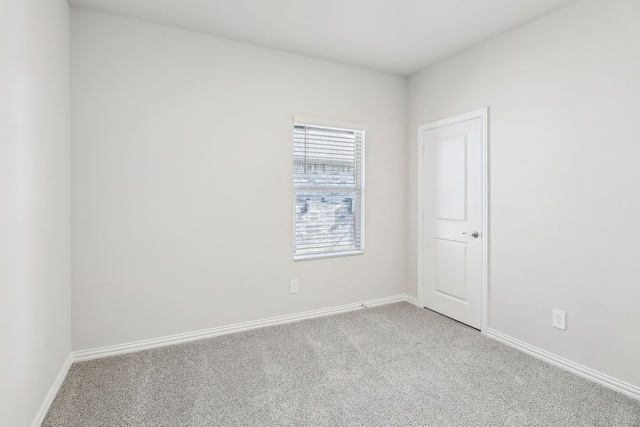 spare room with baseboards and carpet