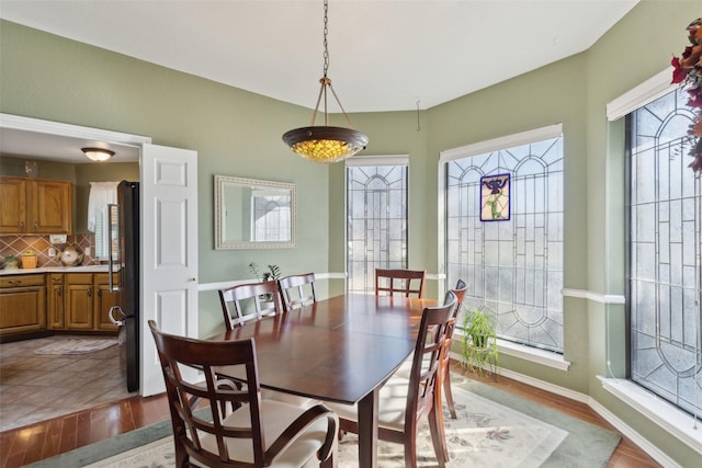 dining area with baseboards and wood finished floors