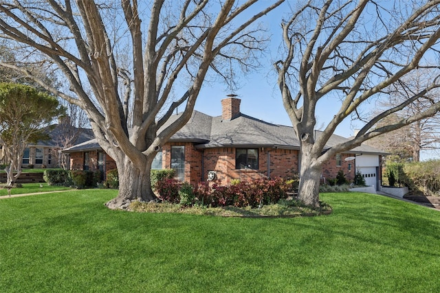 view of front facade featuring roof with shingles, an attached garage, a chimney, a front lawn, and brick siding