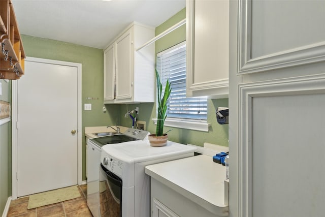 clothes washing area with cabinet space and washing machine and dryer