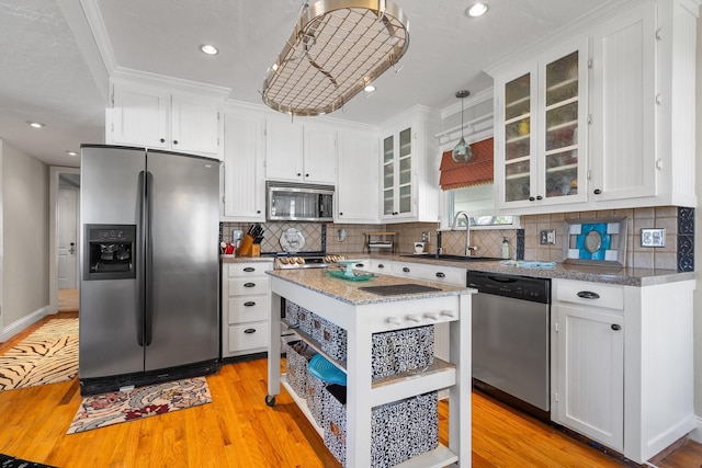 kitchen with a sink, open shelves, appliances with stainless steel finishes, and white cabinets