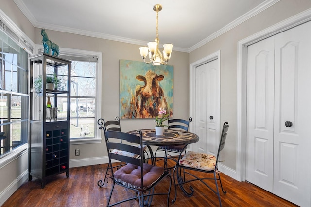 dining area featuring dark wood-style floors, a notable chandelier, baseboards, and ornamental molding