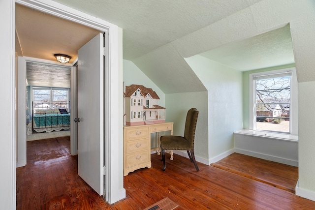 unfurnished office featuring baseboards, lofted ceiling, a textured ceiling, and dark wood-style flooring