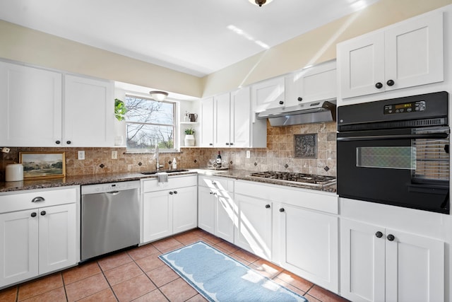 kitchen with under cabinet range hood, a sink, appliances with stainless steel finishes, white cabinets, and decorative backsplash