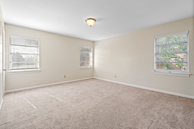 carpeted empty room with baseboards