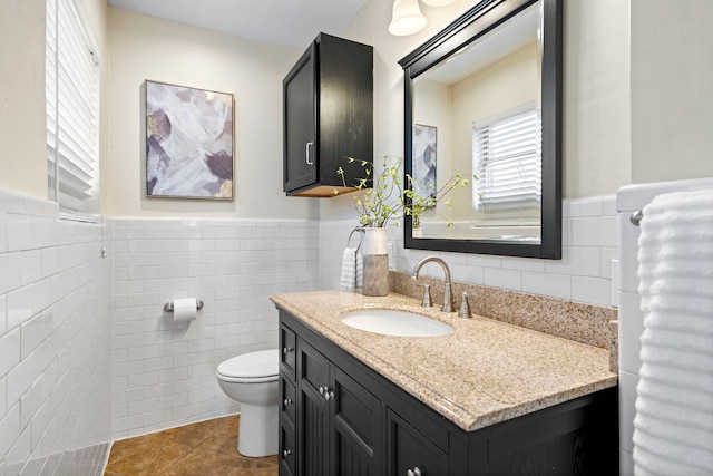 bathroom featuring wainscoting, toilet, and tile walls