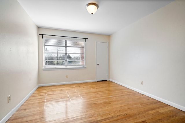 unfurnished room with light wood finished floors and baseboards