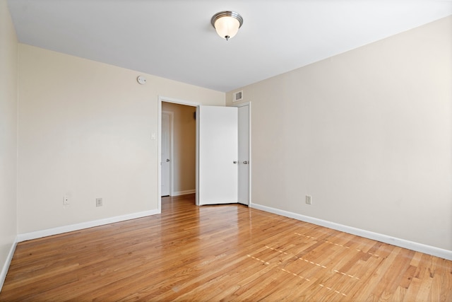 spare room featuring light wood-style floors and baseboards