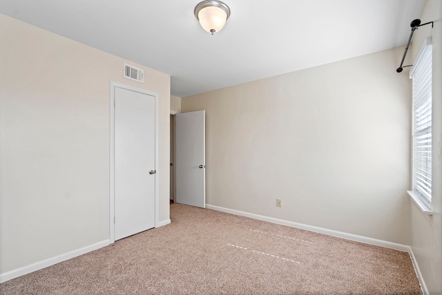 unfurnished room with carpet flooring, baseboards, and visible vents