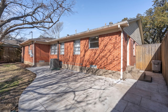 back of house with fence, a patio area, and brick siding