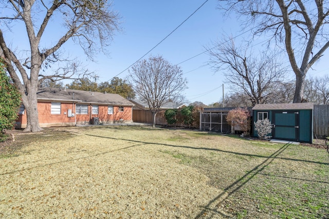 view of yard featuring an outbuilding, a shed, and fence