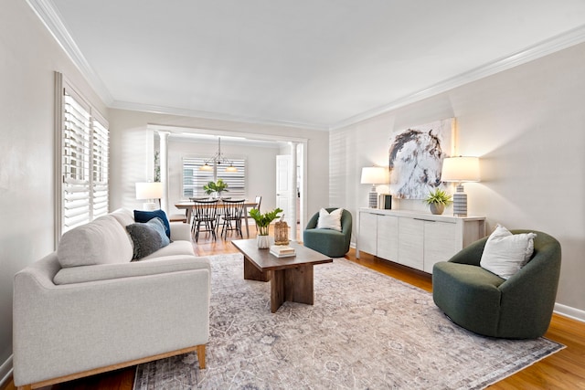 living area with baseboards, wood finished floors, and crown molding