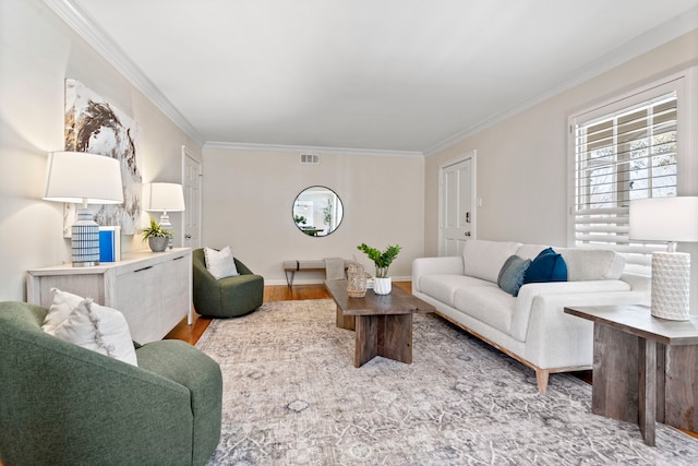 living room with visible vents, baseboards, wood finished floors, and ornamental molding