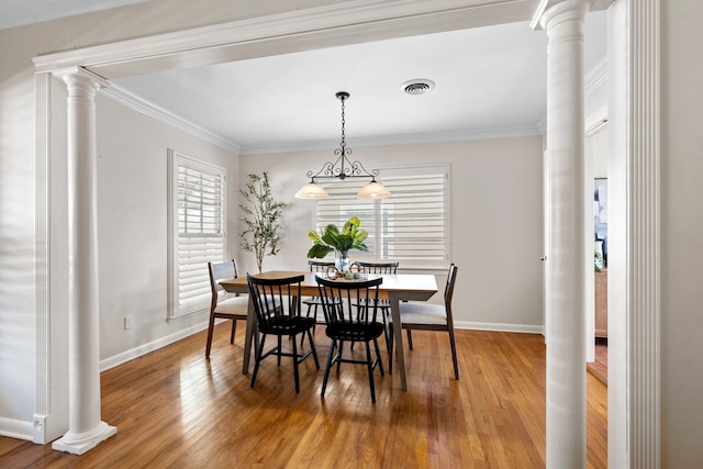 dining area with visible vents, ornamental molding, wood finished floors, and decorative columns