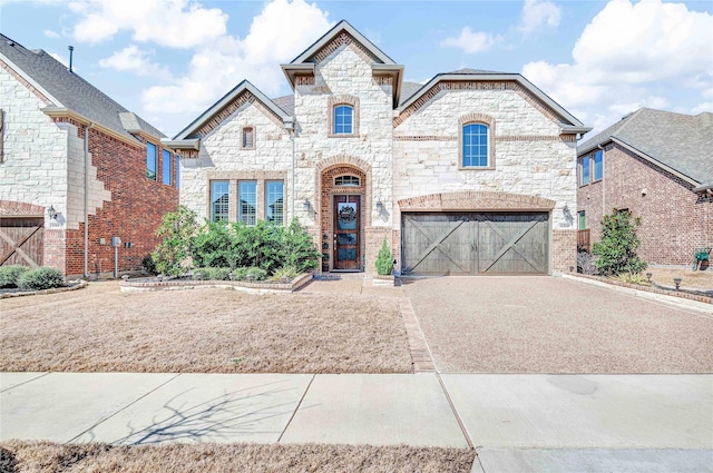 french country inspired facade with stone siding, driveway, and a garage