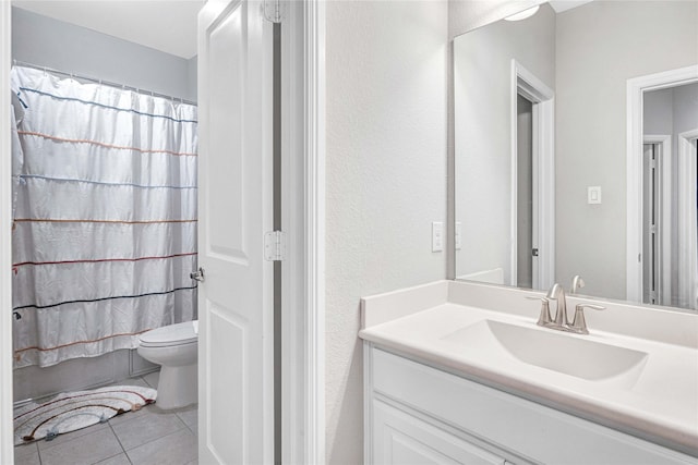 bathroom with shower / tub combo, toilet, vanity, and tile patterned flooring