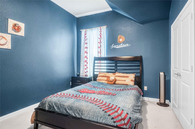 bedroom featuring baseboards, carpet flooring, and a textured wall