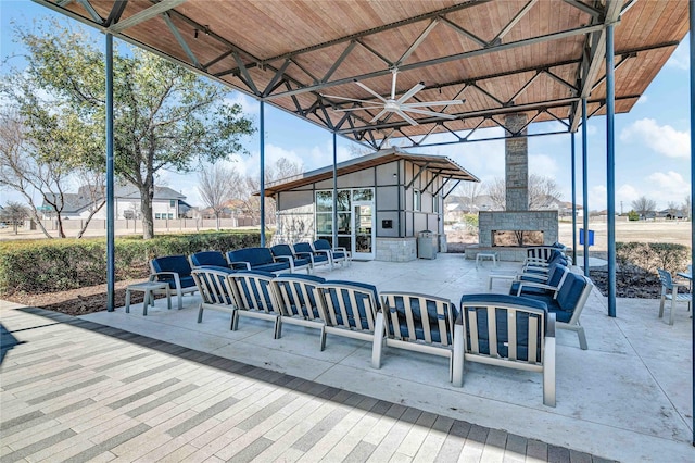 view of patio / terrace with an outdoor living space with a fireplace and ceiling fan