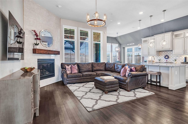 living area with recessed lighting, a notable chandelier, a fireplace, and dark wood-style flooring