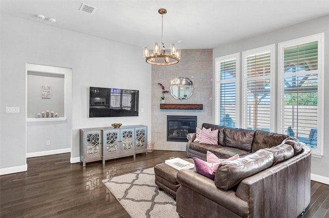 living room featuring dark wood finished floors, visible vents, baseboards, and an inviting chandelier