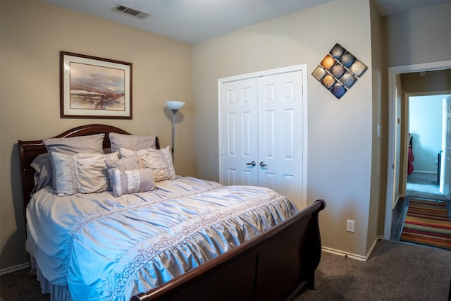 bedroom featuring a closet, baseboards, visible vents, and dark carpet