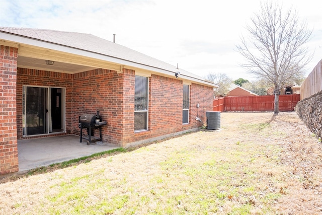 view of yard with a fenced backyard, a patio area, and central AC