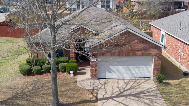 view of front of house with brick siding, an attached garage, and concrete driveway