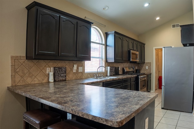 kitchen featuring light tile patterned floors, visible vents, a peninsula, a sink, and appliances with stainless steel finishes