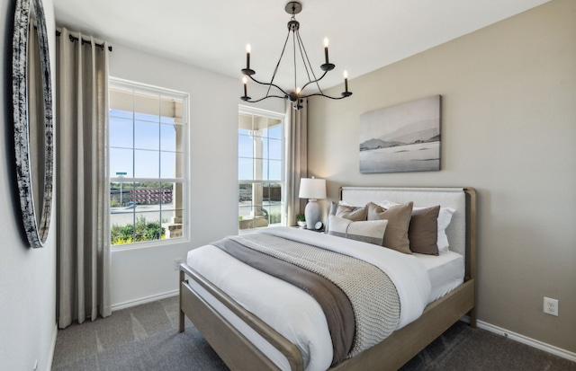 bedroom featuring a chandelier, baseboards, and dark colored carpet