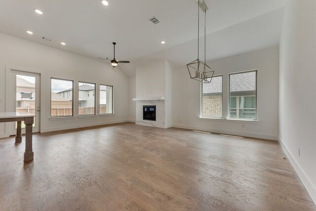 unfurnished living room with a fireplace, recessed lighting, a healthy amount of sunlight, and visible vents