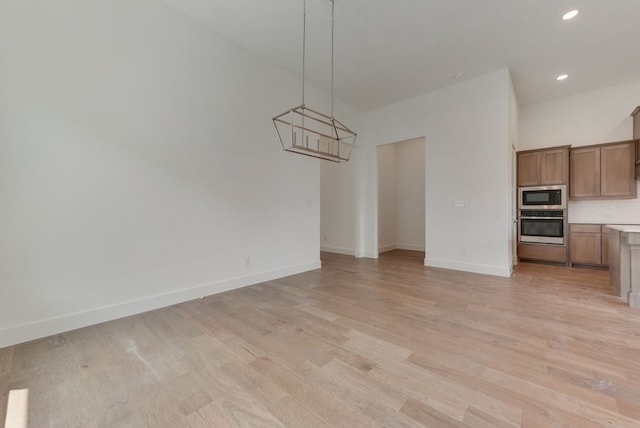 unfurnished dining area featuring recessed lighting, light wood-type flooring, and baseboards