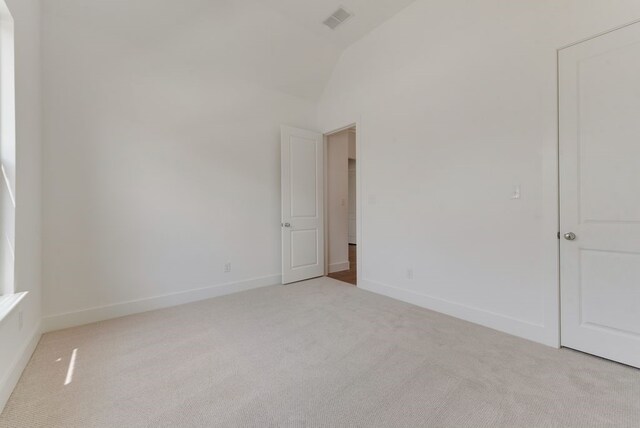 carpeted spare room with visible vents, baseboards, and high vaulted ceiling