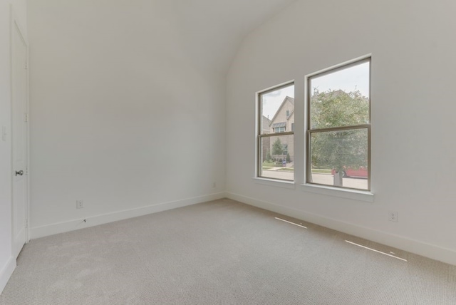 empty room with baseboards, light colored carpet, and lofted ceiling