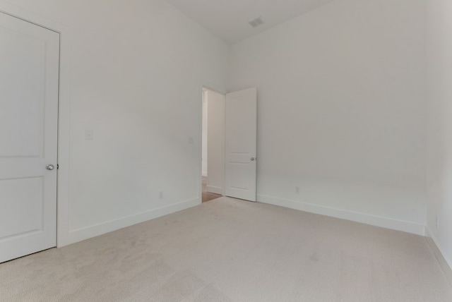 carpeted empty room featuring baseboards and visible vents