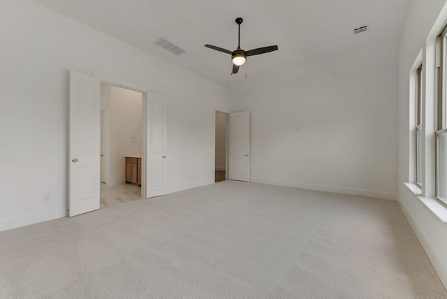 interior space featuring light carpet, visible vents, baseboards, and a ceiling fan