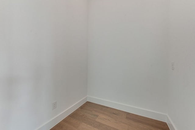 spare room with baseboards and light wood-style flooring