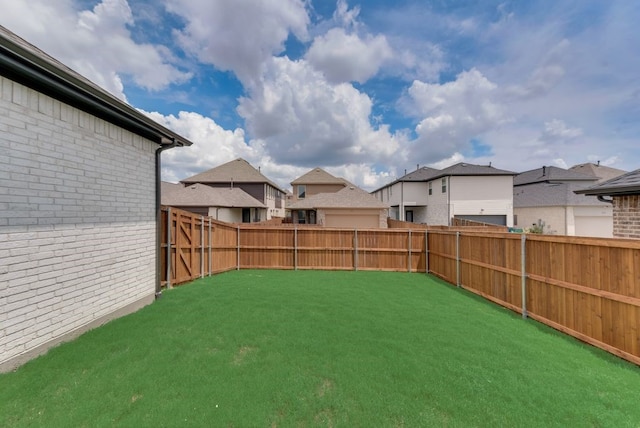 view of yard featuring a fenced backyard and a residential view