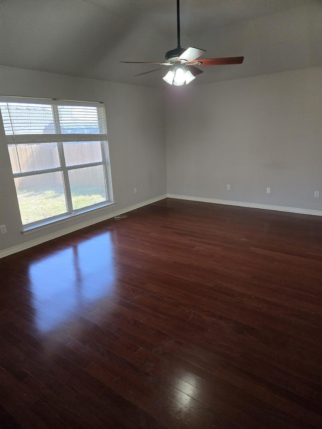 empty room featuring baseboards, dark wood-type flooring, and ceiling fan