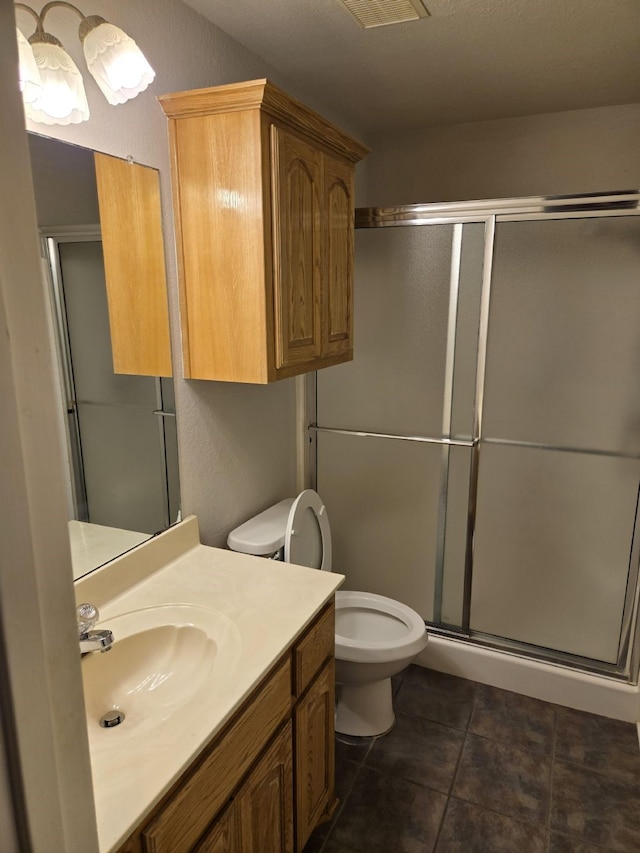 full bath with tile patterned floors, a shower stall, toilet, and vanity