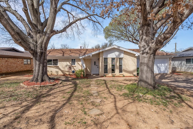 view of front of property featuring concrete driveway, a garage, and brick siding