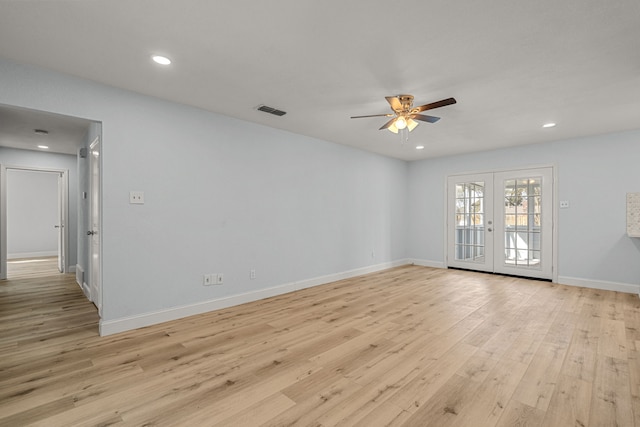 spare room featuring visible vents, a ceiling fan, french doors, light wood-style floors, and baseboards