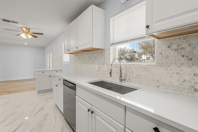 kitchen with a sink, decorative backsplash, light countertops, dishwasher, and marble finish floor