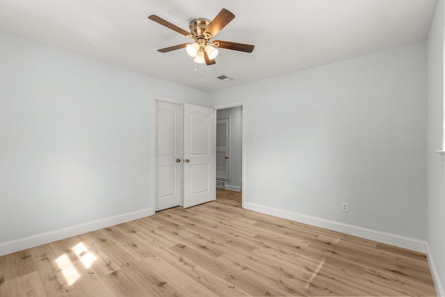 unfurnished room featuring light wood finished floors, baseboards, and a ceiling fan