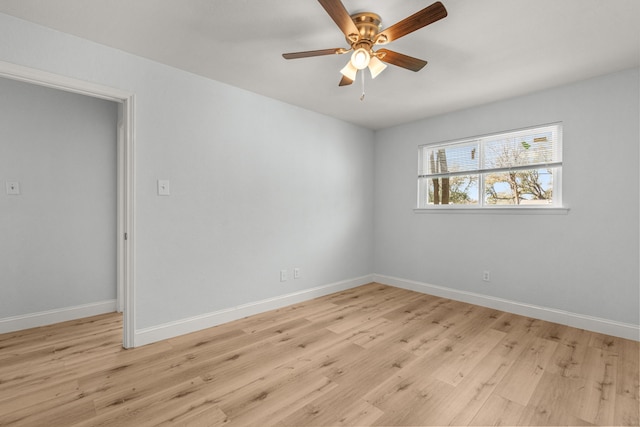 spare room with light wood finished floors, baseboards, and ceiling fan