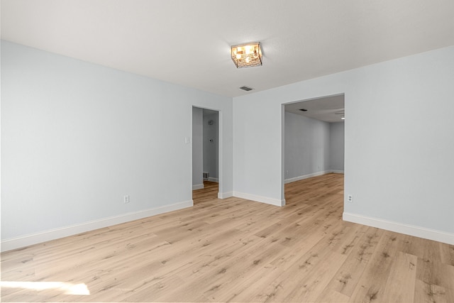 spare room with visible vents, baseboards, and light wood-type flooring