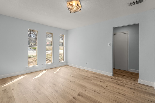 unfurnished room with visible vents, baseboards, and light wood finished floors